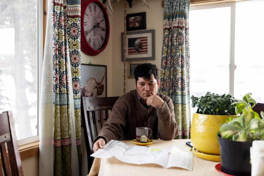 Beau Michael on the Blackfeet reservation in Montana looks over maps showing his plot of land and where Ricketts' fencing currently is located.  He says he has come into conflict with the ranch over the barriers.