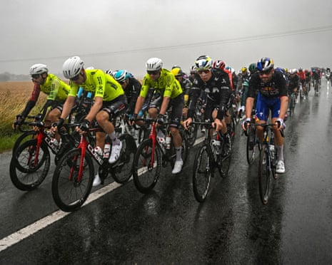The peloton rides in the rain.