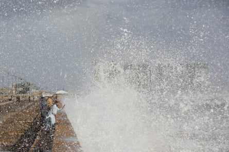 A man with a mobile phone takes a picture of rising waves, before the arrival of the cyclonic storm Biparjoy over the Arabian Sea in Karachi, Pakistan