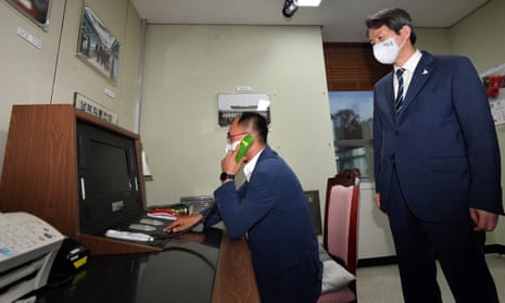 This file photo taken on September 16, 2020 shows South Korea’s Unification Minister Lee In-young (R) looking at the inter-Korean “hotline” during a visit to the south side of the truce village of Panmunjom