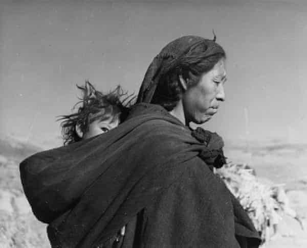 A Bolivian Indian mother carries her baby in a papoose.