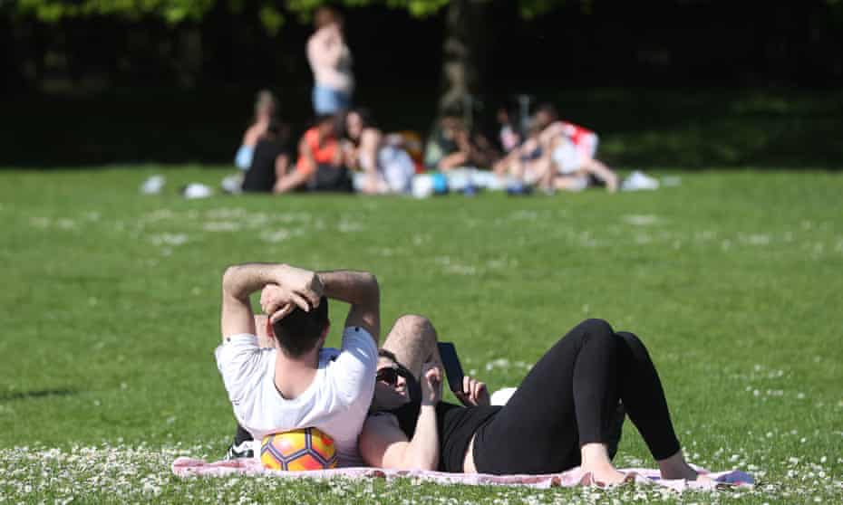People relax in the sun in Regent’s Park, London