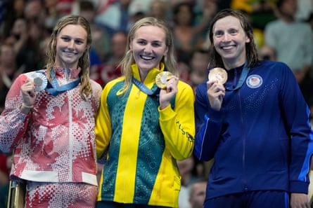 Gold medalist Ariarne Titmus, of Australia, centre, stands with silver medalist, Summer McIntosh, of Canada, left, and bronze medalist Katie Ledecky, of the United States, on the podium after winning the women's 400-meters freestyle final at the 2024 Paris Olympics