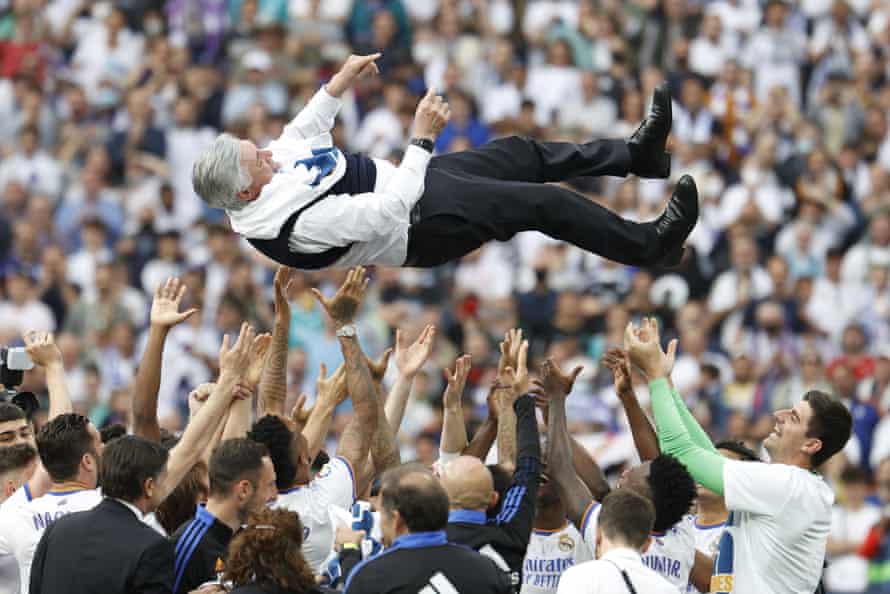 Madrid players celebrate by tossing head coach Carlo Ancelotti in the air.