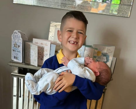 Archie holds his baby brother, Finley