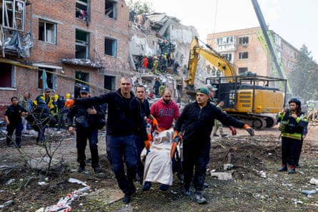 People carry a casualty after strikes on Pryluky.