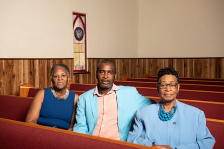 three people sitting in a church pew