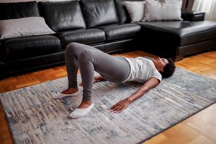Woman practicing a glute bridge exercise in her living room