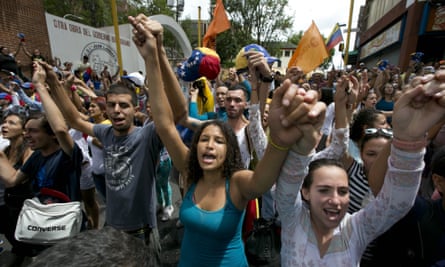 Demonstrators sing Venezuela’s national anthem during a protest against the Maduro government.