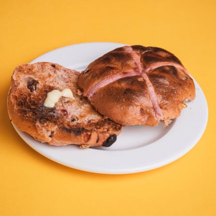 A Waitrose No 1 berry blush hot cross bun, sliced, toasted and buttered, on a white plate