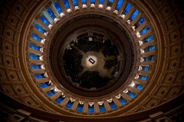 Jimmy Carter's flag-draped casket lies in state beneath a grand domed ceiling, viewed from above