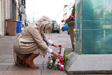 Caroline Martin, the sister of Esther Gibson, who died in the Omagh bombing, lays flowers at the site of the atrocity to mark the 25th anniversary.