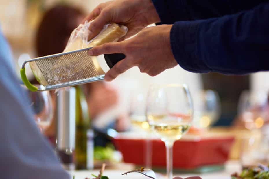 Man grating cheese at dinner party