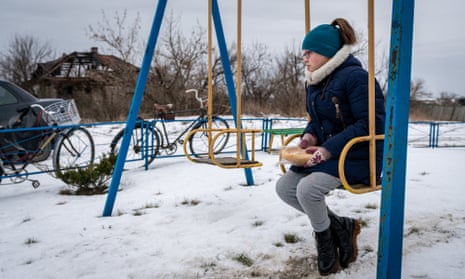 A Ukrainian girl sits on a swing waiting for humanitarian aid in Donetsk Oblast on January 18.