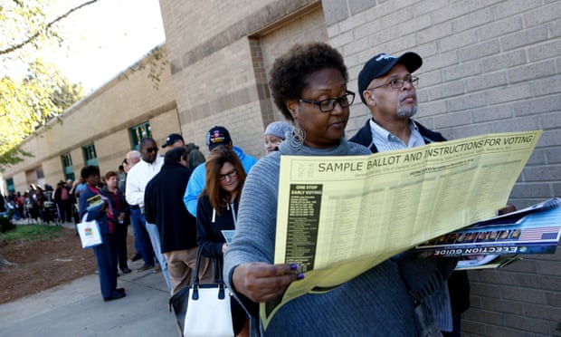 Mavis Wilson looks over a sample ballot as she waits to vote early with her husband, Ron, in Charlotte, North Carolina.