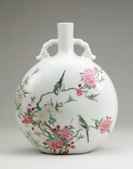 A white flask with pictures of birds on branches bearing pink flowers.