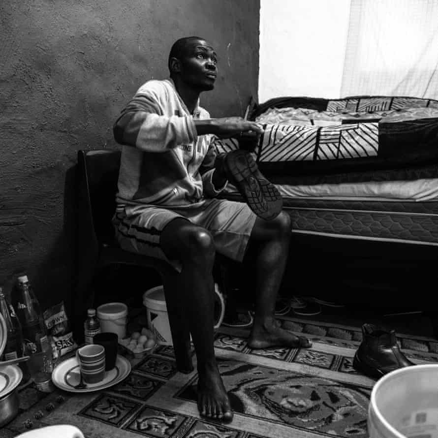 Ghost riders: the invisible lives of Johannesburg food couriers – photo essay | South Africa 9 Paul polishes his shoes every day before work.