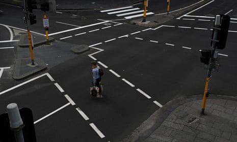 A woman crosses the usually busy intersection of Market Street and Sussex Street in the CBD in Sydney