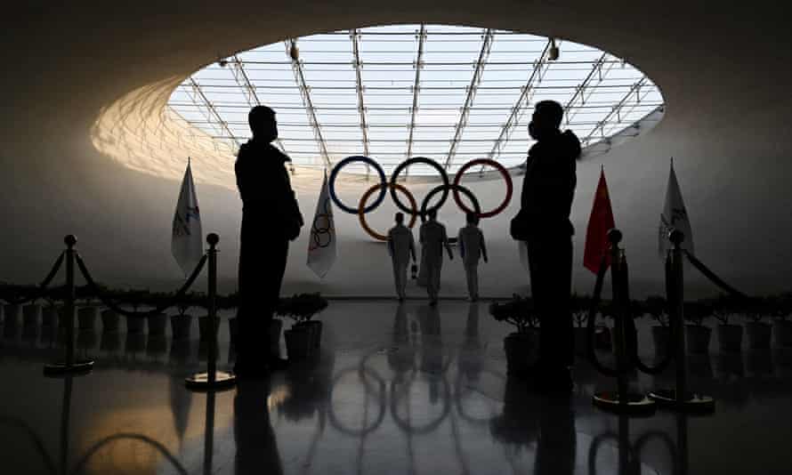 *** BESTPIX *** TOPSHOT-OLY-2022-BEIJINGTOPSHOT - Security guards stand by as workers refuel the Olympic flame in the Olympic Tower in Beijing on January 3, 2022, a month before the opening of the 2022 Winter Olympic Games on February 4, 2022. (Photo by GREG BAKER / AFP) (Photo by GREG BAKER/AFP via Getty Images) *** BESTPIX ***