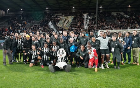 Angers players and staff celebrate after their 2-0 win against Auxerre.