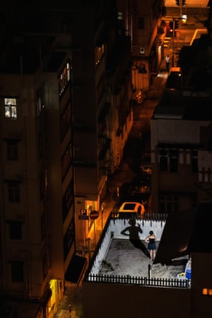 A woman makes a phone call on the roof top in the Tai Hang neighborhood. One of the many photographs I made from our 19th floor apartment overlooking a mostly lower rise area.//I settled for taking pictures of the rooftops and streets below our bedroom window, feeling a bit like Jimmy Stewart in Rear Window. But eventually I began roaming the city at night, seeking whatever relief I could in a world that felt like it was comingto an end.