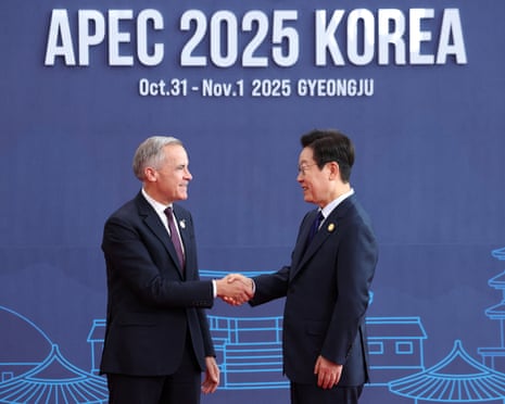 Canada's PM, Mark Carney, shakes hands with South Korea's president, Lee Jae-myung, in front of a blue screen that says 'Apec 2025 Korea'.