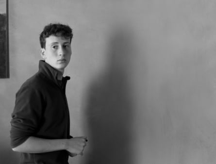 black and white photo of Zac Brettler standing indoors