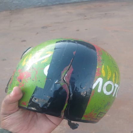 Green motorbike helmet with a crack running through it 