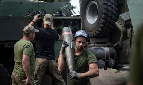 Los militares ucranianos llevan un proyectil de 155 mm a un obús autopropulsado cerca de Bakhmut.