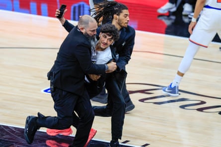 Security escort a man off court after he attempted to take a selfie with Victor Wembanyama