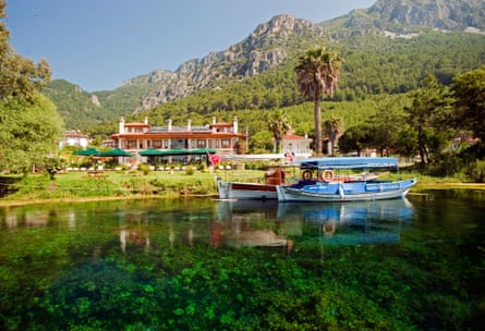 Scenic view of blue creek and a hotel backed by mountains