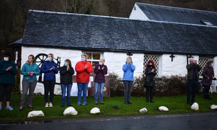 ‘Human kindness will not be locked down’ … people clap as a funeral cortege passes through Glencoe, Scotland.