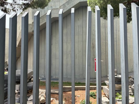 A metal fence outside the museum with several of the bars appearing to be slightly bent apart.