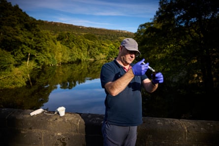 Prof Alistair Boxall taking a water sample from the River Derwent at Calver overlooking Froggat Edge in the Peak District national park.