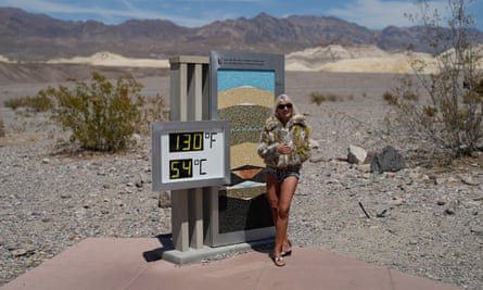 A woman poses by a thermometer on 16 July 2023 in Death Valley national park, California.