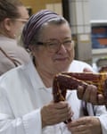 A woman in a chef’s jacket smiles at the camera