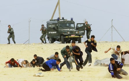 armed soldiers get out of a vehicle to shoot at a group of teenagers who are running away