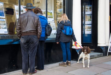 People looking at property in an estate agency window