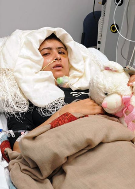 Malala Yousafzai in a hospital bed holding a teddybear