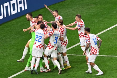 Players of Croatia celebrate with goalkeeper Dominik Livakovic after the FIFA World Cup 2022 round of 16 soccer match between Japan and Croatia at Al Janoub Stadium in Al Wakrah, Qatar