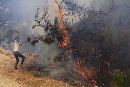 A man tries to prevent a forest fire spreading in Qobayat village, Akkar province.
