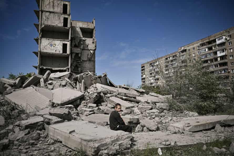 A Ukrainian boy beside a damaged building after a strike in Kramatorsk, eastern Ukraine