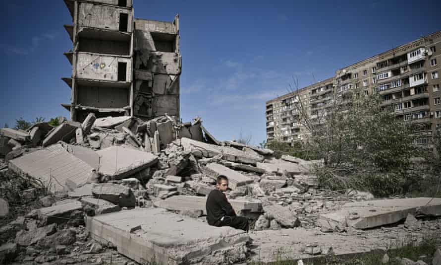 A young boy sits in front of a damaged building after a strike in Kramatorsk in the eastern Ukrainian region of Donbas.