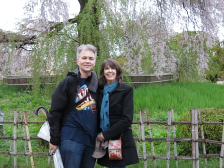 A man and woman stand in front of a flowering tree in Tokyo