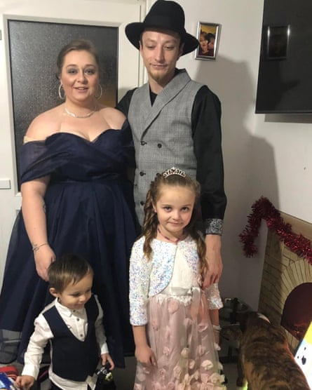 Family of four dressed up smartly with dog to the right