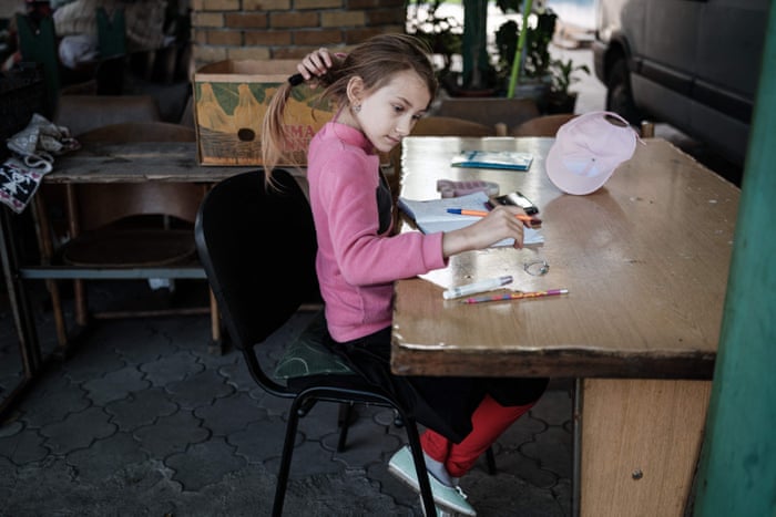 Sasha, 9, studies with a smartphone as she attends online schooling in Pokrovske.