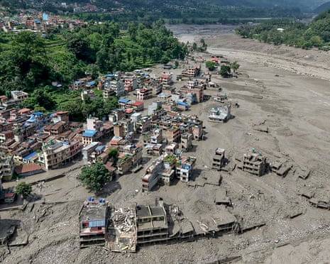 Houses lie partially submerged in muddy water along a riverside at Trishuli Bazar in Nepal’s Nuwakot district after the deadly flash flood