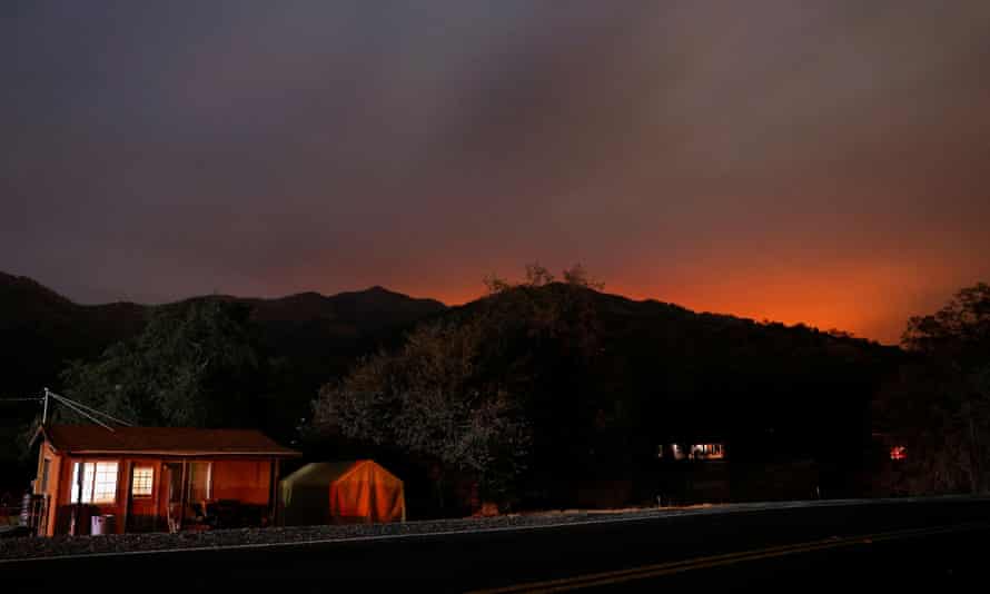 The glow from the KNP Complex fire burning in Sequoia national park is seen in the hills behind homes in Three Rivers, California.