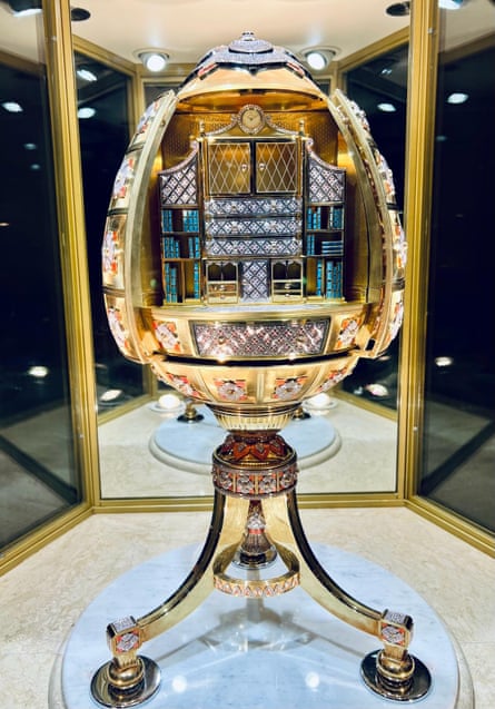 A big gold and jewelled egg on a stand in a display case