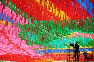 Seoul, South Korea. A worker attaches prayer petitions to lotus lanterns in preparation for the birthday of Buddha